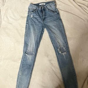 Skinny jeans with two rips in the knees, and light blue